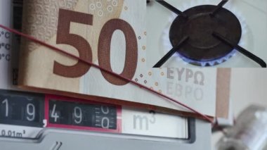 Gaz sayacında dönen numaralardan oluşan bir kolaj. Üstünde 50 Euro 'luk bir banknot ve mutfak ocağında yanan bir gaz ocağı var. Pahalı bir gaz konsepti.