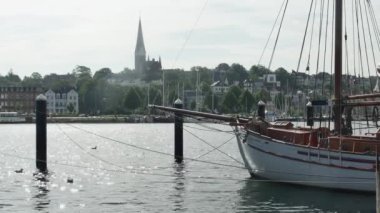 Flensburg, Almanya - 27 Temmuz 2023. Kilisenin önünde demirli beyaz yelkenli gemi
