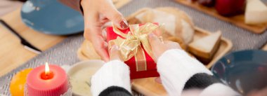 Mutlu bir aile ve kızı evde yemek yerken anneleriyle birlikte hediye kutluyorlar, Noel 'i çocuklarıyla kutluyorlar evde eğlenen aileleri şaşırtıyorlar, Şükran Günü arifesi, mutlu noeller..