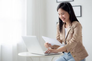 Beautiful young asian business woman using laptop computer working from home for video conference online, businesswoman working with video call for meeting distance and report for finance.