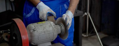 Closeup hands of young man sanding or iron at industrial factory, mechanic working job while polish metal, male having skill built steel with tool, labor and steelworks, industry concept.