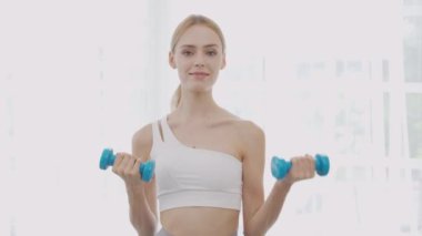 Beautiful young woman workout with lift up dumbbell for muscle while motivation and determined, one person, exercise and sport for muscular arm and hands, recreation and sport for health care concept.