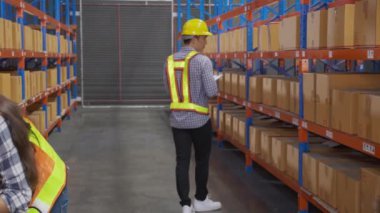 Young man and woman worker check stock and inspection with document on clipboard in the warehouse at factory, worker working at storehouse, logistic and cargo, shipping and distribution.