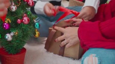 Mutluluğun kapalı elleri Noel 'i kutlamak için hediye kutusuna yay ve süsleme bağladı. Tatil hazırlıkları için sürpriz ve hediyeler, yeni yıl, Şükran Günü arifesi ve xmas..
