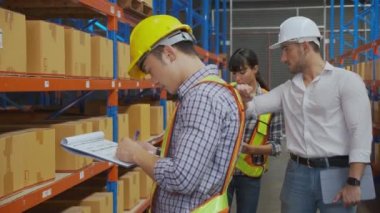 Delikanlı ambalaj ve kontrol belgesine nakliye etiketi yapıştırıyor ve fabrikadaki depoda yönetici konuşuyor, işçi yazma ve teftiş imalatı, lojistik ve nakliye konsepti.