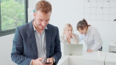 Genç işadamının portresi gülümseyen ve akıllı telefonlu mutlu bir şekilde bakarken, çalışan, yönetici ya da yönetici akıllı telefon, iş konsepti kullanıyordu..