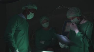 Röntgen çekilirken cerrah ekibi uzman toplantısı ve tedavi için tartışma, hastanedeki ameliyathanede film, doktor sohbeti, tıbbi konsept..