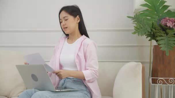 Νεαρή Ασιάτισσα Γυναίκα Άγχος Κάθεται Στον Καναπέ Ανάγνωση Έγγραφο Κοινοποίησης — Αρχείο Βίντεο