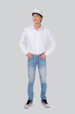 Genç Asyalı bir adam miğfer takıyor ve gülümsüyor. Beyaz arka planda kendine güvenen yakışıklı bir erkek mimar, müteahhit, işçi ya da işçi, endüstriyel konsept..