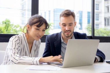 Kafkasyalı genç işadamı, ofiste birlikte çalışan iş kadını yetiştiren girişimci, yönetici ve çalışan, dizüstü bilgisayarı tartışan ve kullanan iki kişi, iş konsepti.