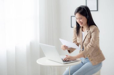 Beautiful young asian business woman using laptop computer working from home for video conference online, businesswoman working with video call for meeting distance and report for finance.