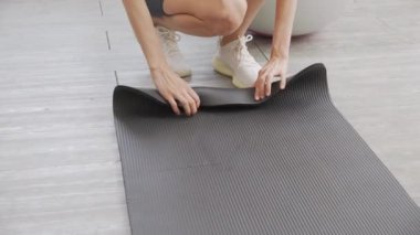Matta yogası ile yere yuvarlanan genç bayanın elleri evde meditasyon hazırlığı ve dinlenme egzersizi için egzersiz, egzersiz ve sağlık için aktivite ve hobilerle yoga yapıyor..