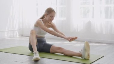 Paspas üzerinde egzersiz ya da yoga yapan genç bir kadın, evde bacak ve ellerle egzersiz yaparken, motivasyona ve egzersize sahip bir kadın, bir kişi, yaşam tarzı ve spor konsepti..