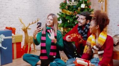 Genç arkadaşlar, Noel arifesinde, Noel arifesinde, Noel arifesinde, bayramında veya tatil konseptinde sosyal medyayı kullanan kadın ve erkek, heyecanlı ve akıllı telefonlardan keyif alarak görüntülü arama yaparlar..