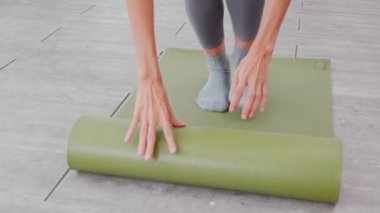 Matta yogası ile yere yuvarlanan genç bayanın elleri evde meditasyon hazırlığı ve dinlenme egzersizi için egzersiz, egzersiz ve sağlık için aktivite ve hobilerle yoga yapıyor..