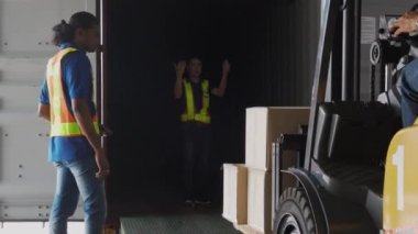 Grup çalışanı ve adam forklift kutusu veya nakliye ve dağıtım için ambalaj kullanıyor fabrikadaki depoda yükleme konteynırları, depoda çalışan çalışanlar, lojistik konsept.