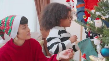 Anne ve babayla mutlu bir aile Noel ağacı süslemesi evde kızıyla birlikte, Şükran Günü arifesi, Noel günü bağ kurma kutlaması, tatilde keyif ve eğlence..