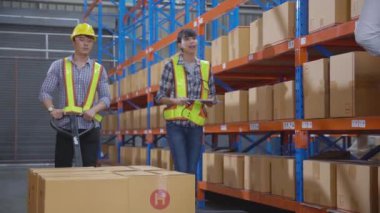 Young man and woman carrying box stack and distribution in the warehouse at factory, worker working holding package in storehouse, logistic and transportation, industrial and cargo concept.