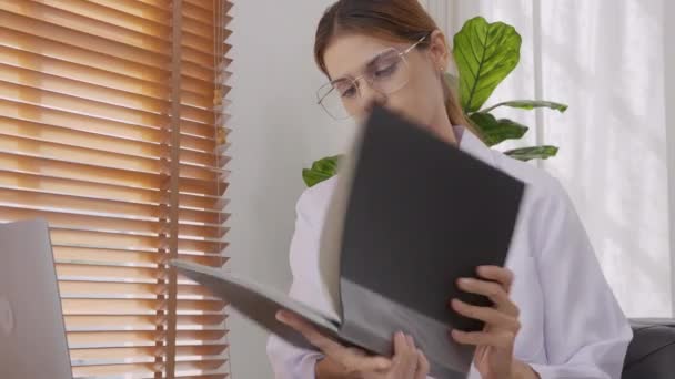 Young Woman Doctor Working While Looking Document Folder Patient Illness — Vídeo de Stock