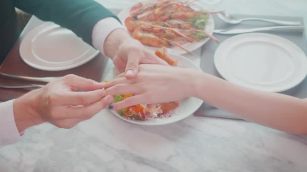 为结婚或订婚而把戒指戴在女人手指上的男人的小手 同时对餐馆的奢华 爱情和未婚夫 结婚纪念日和庆祝会 亲热和结合感到惊奇 — 图库视频影像