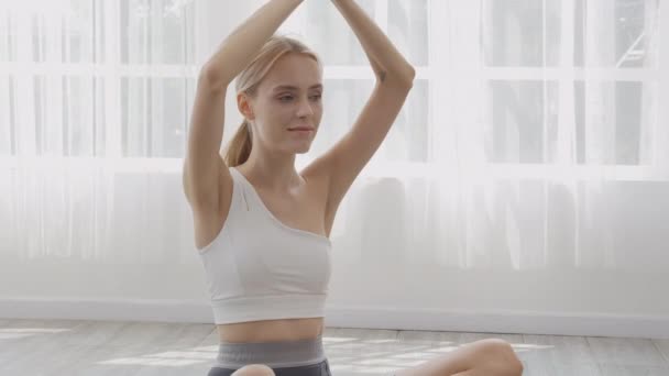 漂亮的年轻女子在健身馆做瑜伽时 有坐有伸展肌肉的手 有练习运动的女性 还有在家里做身体护理和平衡生活的运动 还有运动理念 — 图库视频影像