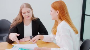 İki işadamı ofiste planlama ve strateji pazarlama ekibiyle bir araya geldi, iş kadını grafik ve grafik raporuyla yatırım ve istatistikleri hakkında konferans düzenledi.