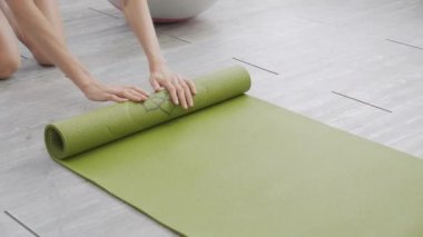 Matta yogası ile yere yuvarlanan genç bayanın elleri evde meditasyon hazırlığı ve dinlenme egzersizi için egzersiz, egzersiz ve sağlık için aktivite ve hobilerle yoga yapıyor..