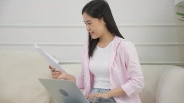 Genç Asyalı iş kadını dizüstü bilgisayarda çalışıyor ve kağıt üzerinde kâr elde etmek için grafik ve çizelge ararken, evde başarı elde etmek için iş kadını yatırım ve gelir arıyor, bilgi verileri.