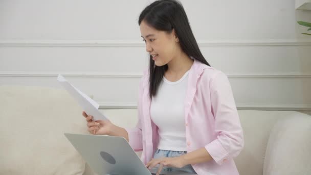 年轻的亚洲女商人在笔记本电脑上工作 在纸上寻找利润的图表和报告 而在家里获得成功 女商人寻找投资和收入 信息数据 — 图库视频影像
