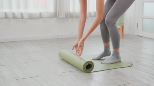 床にマットヨガで転がる若い女性の手を閉じて 自宅でのレクリエーションのための瞑想と運動 トレーニングワークアウトや健康のための活動や趣味を持つヨガの練習 — ストック動画
