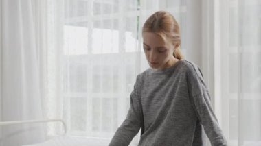 Young caucasian woman depressed while friends encourage in the bedroom at home, relation and assistance with cheering while unhappy and worried, lifestyles and feeling emotion with consoling concept.