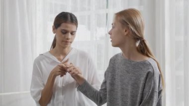 Young caucasian woman depressed while friends encourage in the bedroom at home, relation and assistance with cheering while unhappy and worried, lifestyles and feeling emotion with consoling concept.