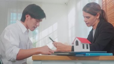 Emlakçı kadın ve müşteri Asyalı erkek, ev ve sigorta, konut ve iş konseptine yatırım danışmanlığı konusunda anlaşma sağlandıktan sonra el sıkışırlar..