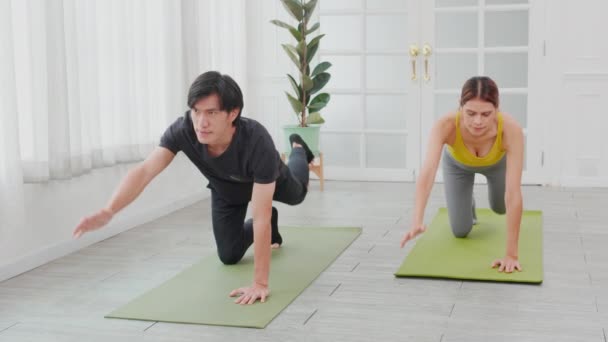 年轻女子和亚洲男子在家里做运动时 手和腿伸展在垫子上 身体强壮有力地进行体重训练 两个人 运动理念 — 图库视频影像