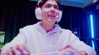 Genç Asyalı adam kulaklık takıyor video oyunu oynuyor ve mikrofon, oyun ve esport ya da heyecan verici, yayın ve eğlence konseptiyle oyuncu seçimi yaparken çevrimiçi canlı yayın yapıyor..