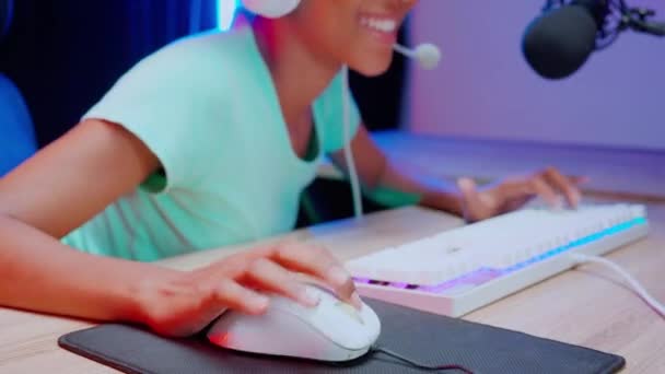 ヘッドセットを身に着けているアフリカ系アメリカ人女性の手は ビデオゲームをプレイし 自宅でマイクでオンラインでライブストリーミング ゲームやスポーツやキャスティングゲーム 放送やエンターテイメントの概念 — ストック動画