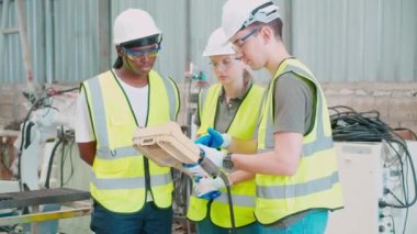 Ekip mühendisi erkek ve kadın robot silahlanma teknolojisi hakkında konuşuyor ve anlatıyor. Teknoloji zekası ve fabrikada eğitim için yenilik, insanlar makine ve endüstri konseptiyle uzaktan kumanda kullanıyorlar..