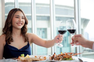 Kutlama için restoranda bir kadeh şarap eşliğinde bir araya gelen mutlu genç çift, romantik ve ilişkili erkek ve kadın, iki kişi, sevgililer günü ve tatil konsepti.