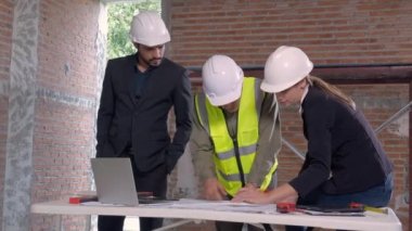 Ekip mimarı veya mühendis erkek ve kadın inşaat alanında emlak planlaması ve stratejisi için buluşuyorlar, müteahhit ve ortak konuşuyor ve arıyor, endüstriyel konsept.