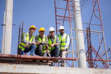 Bir grup müteahhit ve mimar ustabaşıyla birlikte proje planlama projesini işçilere ve proje, inşaat alanı, geliştirme ve yapıya bakmaları için planlama sahasından bahsediyorlar..