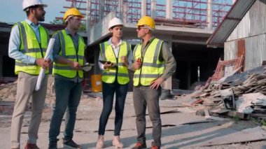 Grup mühendisi toplantısı. Lider inşaat alanında çalışan işçiyle planlama ve araştırma yaparken müteahhit ve mimar inşaat sahası ve teftişi, endüstriyel konsepti tartışacak..