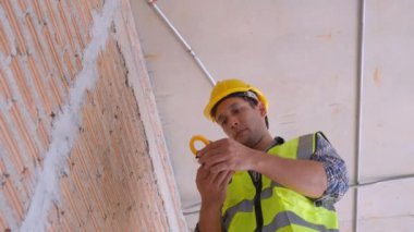 Genç mühendis, evdeki elektriği tamir ediyor, elektrikçi tamir ediyor ve bakımını yapıyor. Evdeki sayaç gerilimini kontrol ediyor, elektriği kontrol ediyor, endüstriyel konsepti kontrol ediyor..