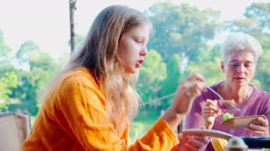 Two senior woman and teenager talking and leisure in camping, activity recreation and leisure picnic while breakfast together in morning in weekend, travel trip in holiday, party in vacations.