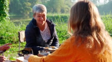 Two senior woman and teenager talking and leisure in camping, activity recreation and leisure picnic while breakfast together in morning in weekend, travel trip in holiday, party in vacations.