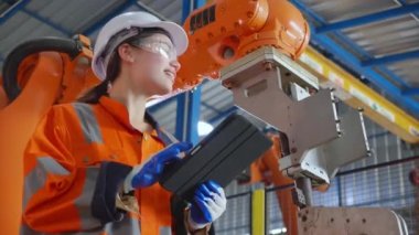 Genç Asyalı mühendis kadın denetim robotu silahlandırıyor teknoloji zekası ve yenilik fabrikada dijital tablet, teknisyen kontrol ve bakım robotu, endüstriyel konsept.
