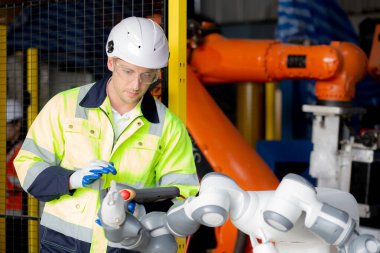 Genç mühendis kontrol ve onarım robotları silahlandırıyor teknoloji zekası ve yenilik fabrika endüstrisinde, teknisyen robotu inceliyor ve onaylıyor, müfettiş ve endüstri kavramı.