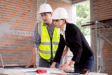 Ekip mimarı veya mühendis erkek ve kadın inşaat alanında emlak planlaması ve stratejisi için buluşuyorlar, müteahhit ve ortak konuşuyor ve arıyor, endüstriyel konsept.