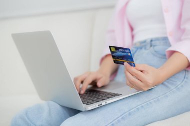 Kanepede oturan kadının elleri dizüstü bilgisayarla online alışveriş yapıyor kredi kartıyla mutlu kadın ödemeleri kanepe, satın alma ve ödeme, iş ve teknoloji konsepti.