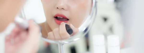 สาวเอเช สวยงามใช ปสต แดงบนปาก สาวสวยมองหน ากระจกส าหร บแต งหน าเคร — ภาพถ่ายสต็อก