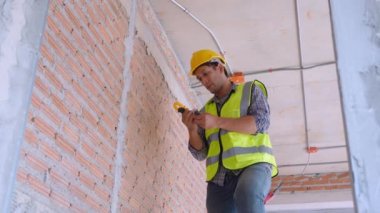Genç mühendis, evdeki elektriği tamir ediyor, elektrikçi tamir ediyor ve bakımını yapıyor. Evdeki sayaç gerilimini kontrol ediyor, elektriği kontrol ediyor, endüstriyel konsepti kontrol ediyor..